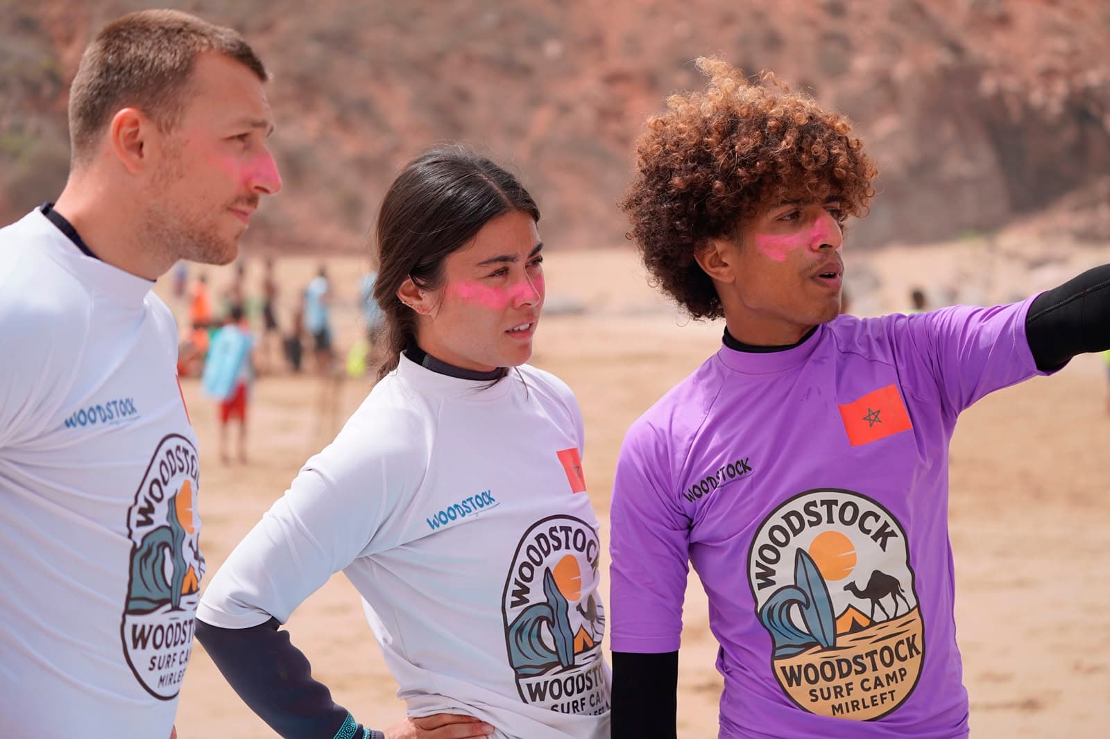 Ayoub coaching surfers on the beach in Mirleft